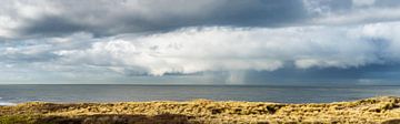 Vue panoramique d'une formation nuageuse avec pluie hivernale et tempête de grêle au large de la côt sur John Duurkoop