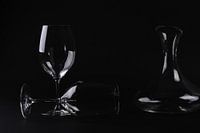Two glasses and decanter against black background