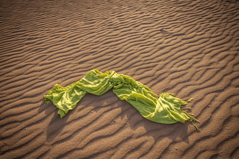 A green scarf with a wavy sand pattern