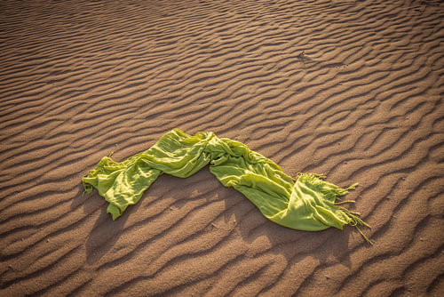 A green scarf with a wavy sand pattern