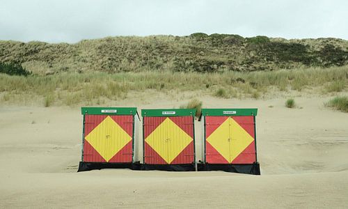 Drie strandhuisjes in geel en rood