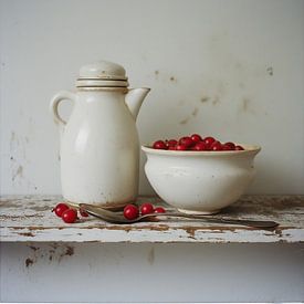 A still life of a milk jug with white pottery bowl filled with red berries on wooden board. by J.a Dijkstra