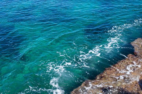 Helder zeewater stroomt over de rotsen 2