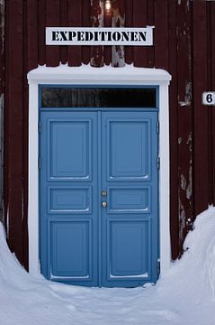 Blue double door in reddish-brown facade