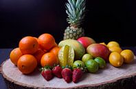 Orangen, Mangos, Papaya, Erdbeere, Ananas, Limetten und Zitronen auf Holzscheibe angeordnet von Babetts Bildergalerie Miniaturansicht