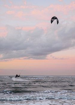 Kitesurfer bei einem pastellfarbenen Sonnenuntergang am Meer in Ouddorp