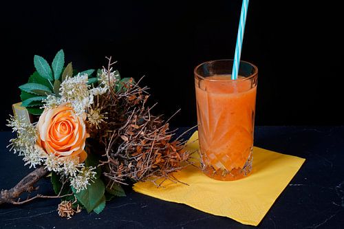 Sinaasappel papaya banaan smoothie in een glas.