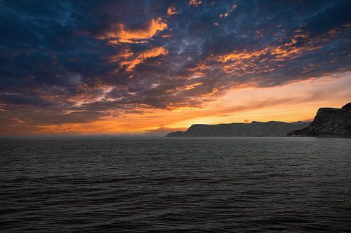 Westkaap in Noorwegen. Fjord en zee met zonsondergang en bergen aan de kust