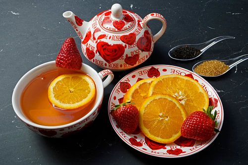 Zwarte thee met aardbei en sinaasappel, versierd met fruit