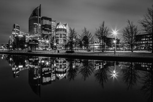 Zwart-wit nachtfoto van de skyline van Den Haag met reflectie