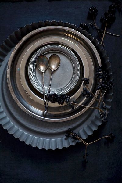 zilveren lepeltjes met tinnen bordjes en springvormen op een donkere achtergrond van BeeldigBeeld Food & Lifestyle