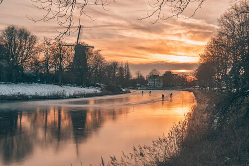 Sunset with mill, skaters and ice
