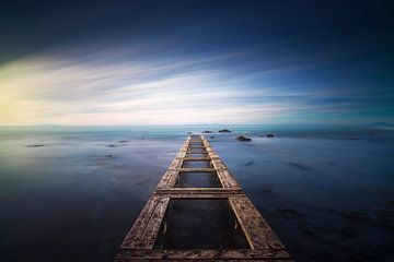 Holzsteg bleibt in einem blauen Meer. Langzeitbelichtung.