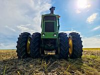 Groene John Deere trekker op een gecultiveerd veld