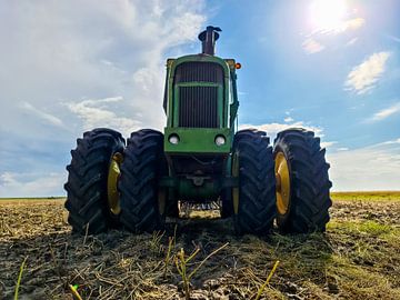 Groene John Deere trekker op een gecultiveerd veld van MPfoto71