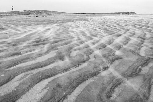 Le vent tourbillonne sur la plage d'Ameland près du phare