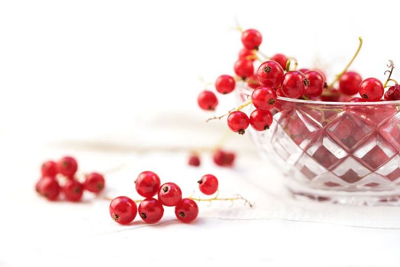 beautiful red currant berries from the garden in a glass bowl and on the table, background with copy by Maren Winter