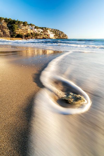 Strand in Mallorca bij zonsondergang met golven die op het strand rollen van Daniel Pahmeier