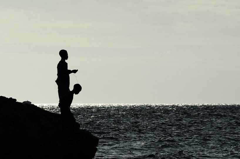 Jongen op rotsen aan het vissen par Christopher Lewis