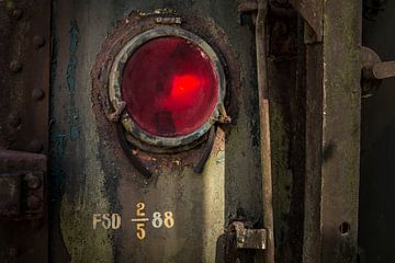 Details van een rode lamp van een  oude verlaten trein op een doodlopend spoor.