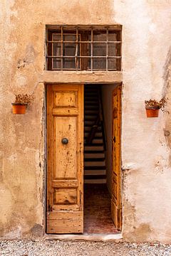 Mediterranean wooden open door with staircase behind it  by Dafne Vos