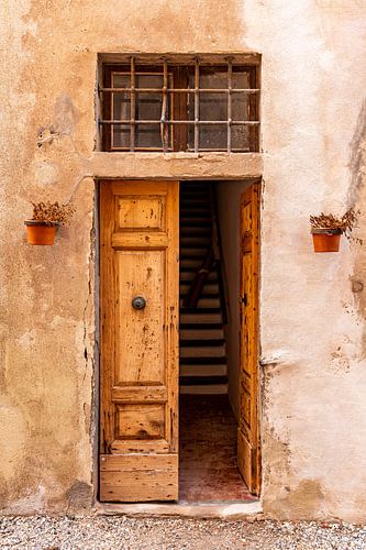 Mediterranean wooden open door with staircase behind it 