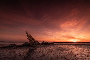 Scheepwrak bij zonsondergang.