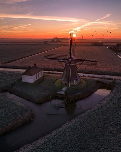 Lever du soleil près du moulin dans le polder