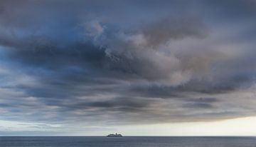 Ship on the ocean with heavy cloud cover by Harrie Muis