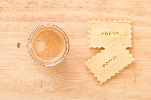 Twee koekjes met Coffee erop en een kop koffie