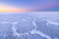 Schöne Strukturen auf einem eisbedeckten IJsselmeer im Winter. Am Horizont geht die Sonne langsam au von Bas Meelker Miniaturansicht