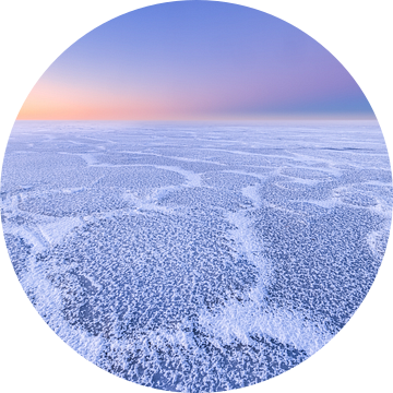 Mooie structuren op een met ijs bedekt IJsselmeer tijdens de winter. Aan de horizon komt de zon lang van Bas Meelker