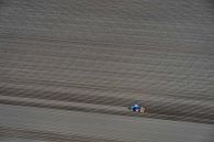 lone tractor on empty field by Ed Dorrestein thumbnail