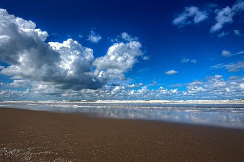 Zuiderstrand bij Scheveningen met blauwe lucht en witte wolken.