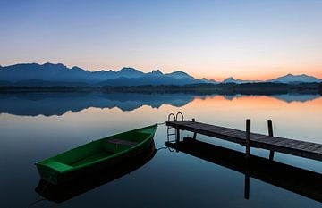 Boot am Steg mit Alpenpanorama im Sonnenuntergang