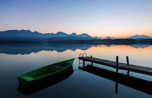 Boat at the jetty with alpine panorama in the sunset