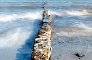 hölzerne Buhnen als Küstenschutz im Meer an einem sonnigen Tag, glattes Wasser bei langer Belichtung