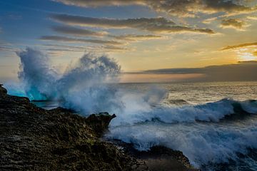 Golven spatten uiteen op de rotsen voor de kust