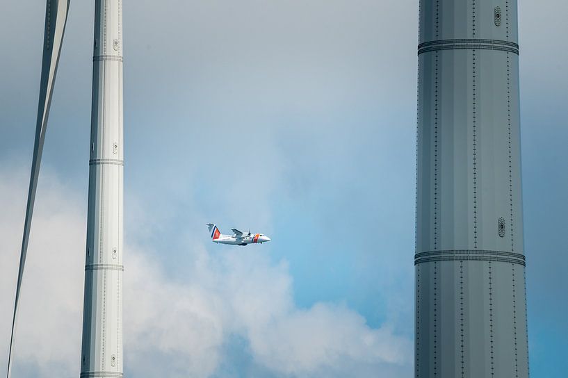 Flugzeug der Küstenwache zwischen Windkraftanlagen von Jan Georg Meijer