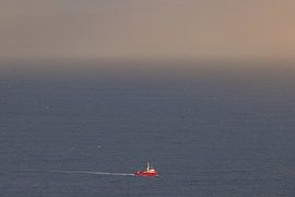 Rotes Fischerboot im Ozean – Ruhe und Weite am Horizont