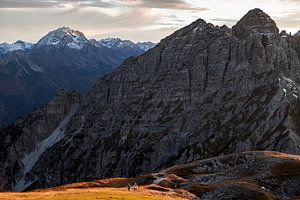 Hiken in de alpen in de herfst. Een stelletje loopt samen een berg op van Hidde Hageman