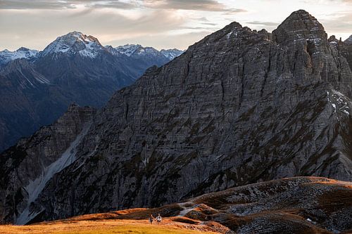 Hiking in the Alps in autumn. A couple walks up a mountain together