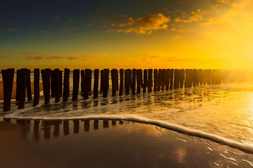 Nuages hollandais et brise-lames typiques de poteaux en bois le long de la côte zélandaise par gaps photography
