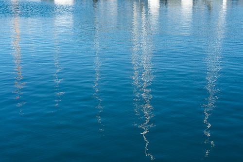 Weerspiegelingen van boten in het blauwe zeewater