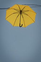 A yellow umbrella in the grey-blue sky