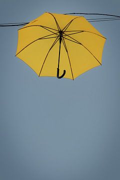 Een gele paraplu in de grijsblauwe lucht van stewic_