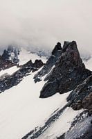 Berg top met sneeuw door wolken