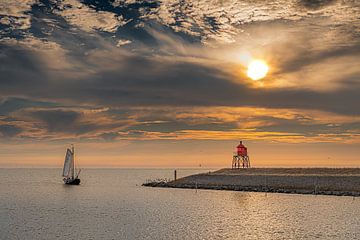 Sunset at Stavoren harbor and one last sailboat by Harrie Muis