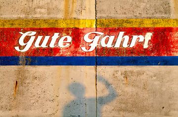 Schaduwfiguur voor kleurrijke muur met belettering van Alexander Baumann