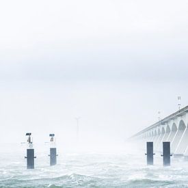 The beautiful zeeland bridge pictured in a different way during a bleak spring storm. by thomas van puymbroeck